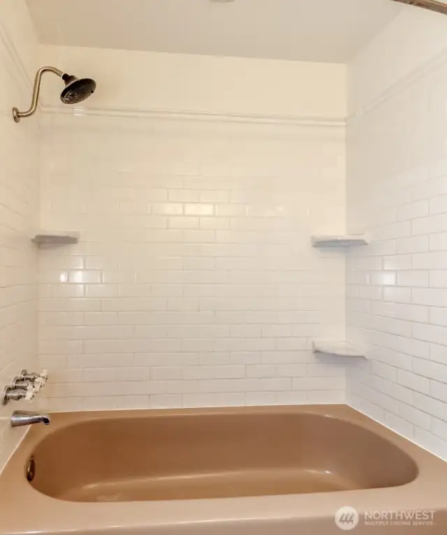 Full bath tub/shower combo.  Flooring in bath is slate.
