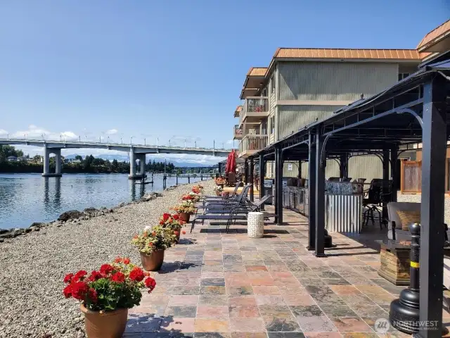 Over 1000 sq ft of patio with 6 gazebos covering the outdoor kitchen with 2 bbqs, 2 fridges, sink and a 14' bar, firepit with a sofa and chairs to relax and a table and chairs. Plus 4 more tables and chairs and another covered seating area for more private conversations. Just steps from the water where a family a seals will great you in the eveings as they catch their diner and every once in a while, the orcas will cruse on by.