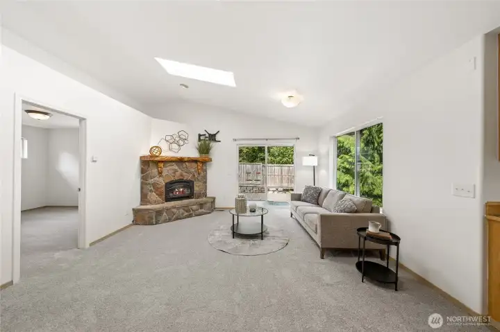 Vaulted ceilings and a stunning stone hearth create a warm, welcoming living room.