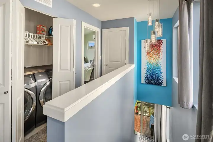 The upper floor hallway is open to take in natural light. Samsung smart washer and dryer.