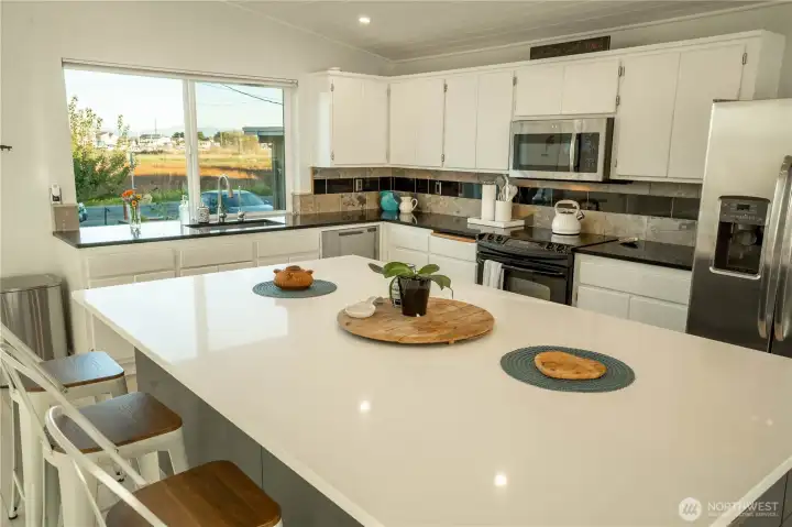 Very spacious kitchen island with barstools.