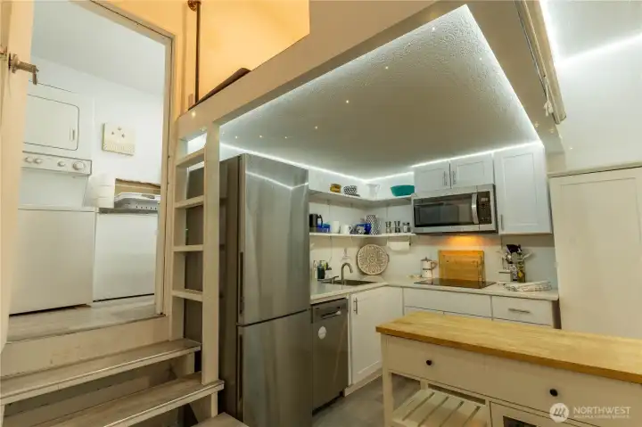 Fully self contained adjacent studio space with washer and dryer to the left and a full bath beyond.  Sleeping loft is above the kitchen.