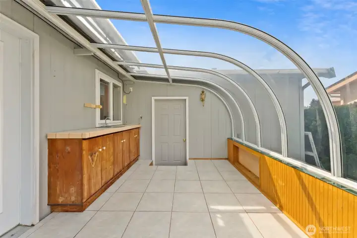 Sunroom with storage and entrance into patio and garage.