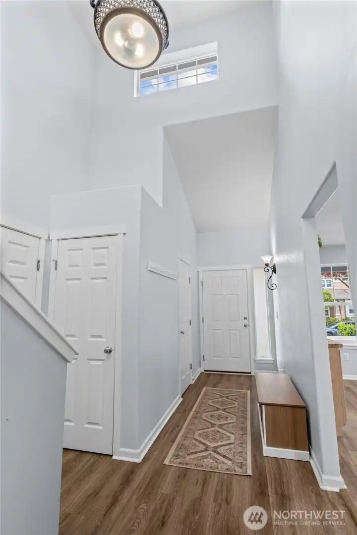 ENTRY | As you step into the home, this light-filled entry leads to a powder room on the right and around the corner to your right is the closet and entry to the garage. On the left is the kitchen.