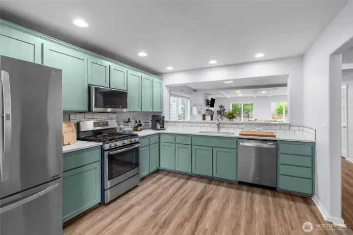 KITCHEN LOVE | Located at the front of the home, this kitchen is LARGE and features stainless steel appliances, quartz countertops, laminate flooring, and recessed lighting.