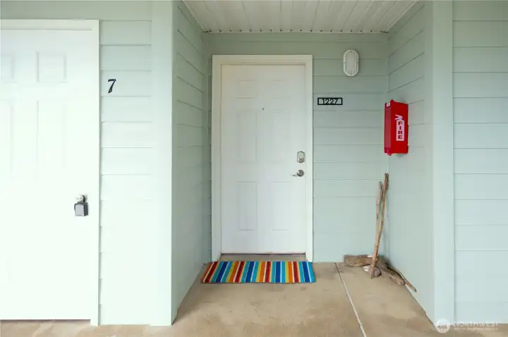Front door to unit with storage closet to left