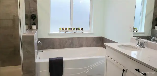 A Picture of the 5 Piece Custom Primary Master Bathroom Showing Separate Soaking Tub surrounded in Tile.