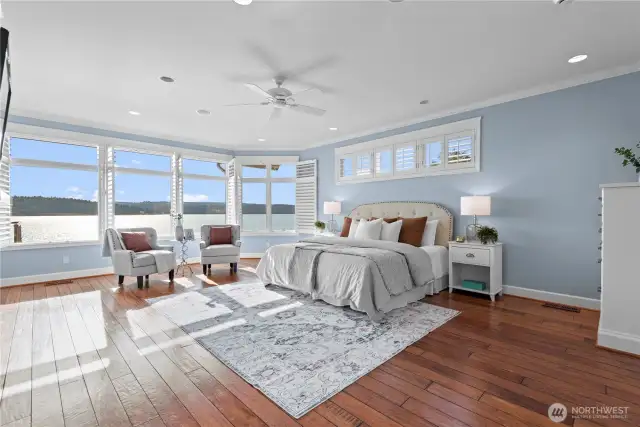 The primary suite is a serene retreat,  featuring expansive windows that frame  stunning water views.