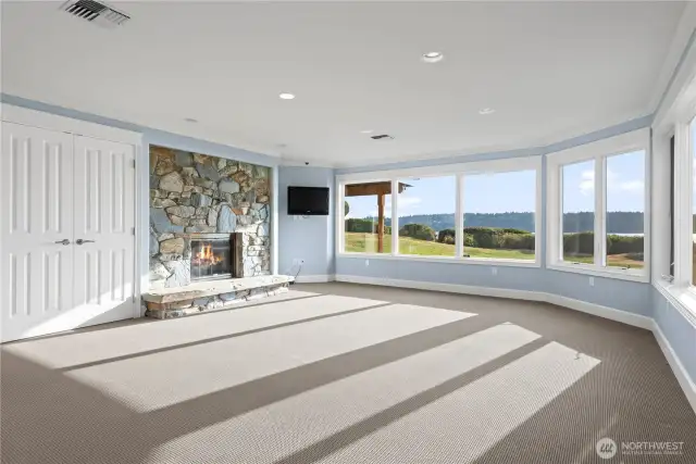 Step into the inviting downstairs bonus room,  where comfort meets elegance. This  versatile space features a cozy fireplace,  perfect for creating a warm and welcoming  atmosphere during cooler months. Large  windows frame stunning views, allowing  natural light to fill the room and connect you  with the beauty of the outdoors.