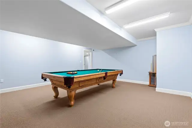 A classic pool table serves as the focal point,  offering endless hours of fun and friendly  competition. The spacious layout ensures  ample room for play and socializing,  creating a perfect setting for gatherings with  family and friends.