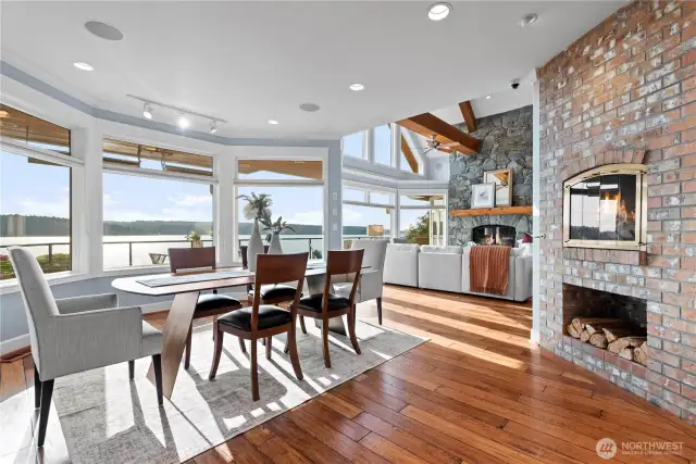 Experience the harmonious flow where the  living room's expansive windows effortlessly  transition into the dining room. This open  design creates a sense of continuity and  connection, enhancing the home's  welcoming atmosphere. The dining area is  beautifully framed by another set of large  windows that open directly to the patio,  inviting natural light and offering a seamless  indoor-outdoor living experience.