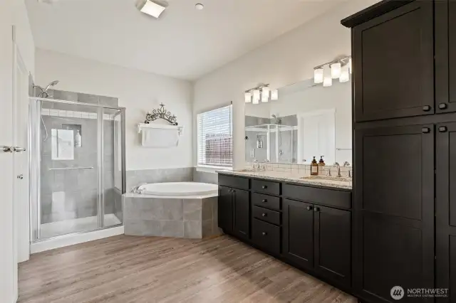 Large ensuite with dual sinks, and stone countertops
