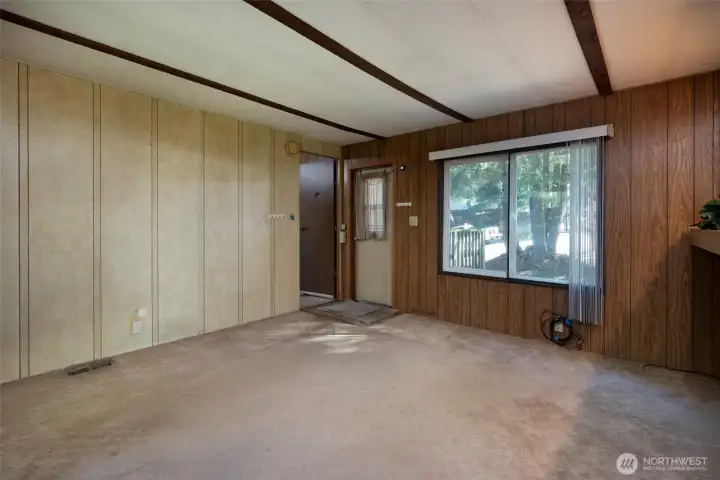 Front door into living room and door into primary bedroom.