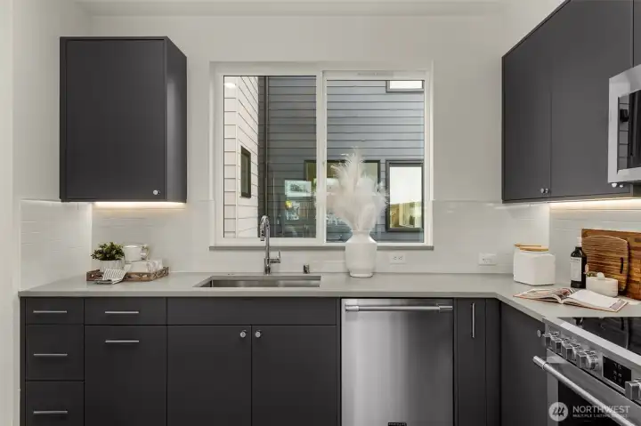 Everyday tasks feel brighter with this kitchen sink framed by a large window, bringing natural light and outdoor views into the heart of the home. Photos are of model home with similar fixtures & finishes.