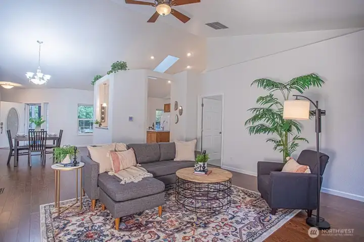 Living room open to the dining room and kitchen beyond.  Primary bedroom on the right.
