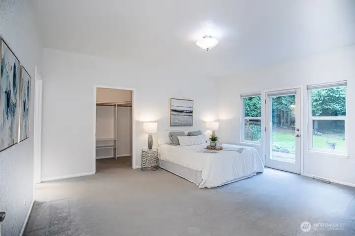 Primary bedroom 1 with door to back deck and lots of natural light.
