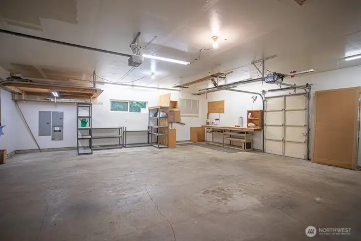 Oversized garage with door to storage shed.