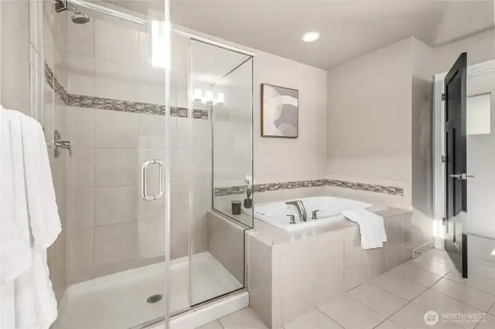Luxurious tiled primary with separate shower and soaking tub.