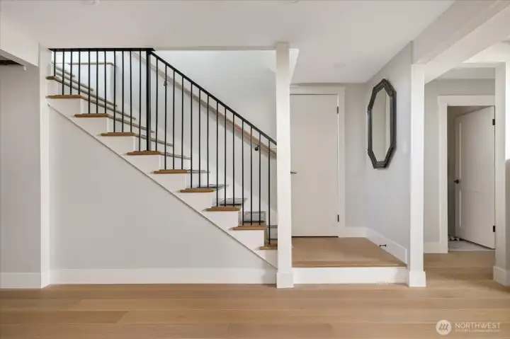 Primary residence stairs to the lower level showing entrance to the half bath at right.