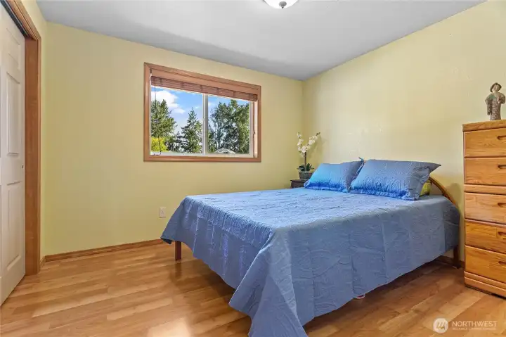 Second bedroom featuring large windows that provide an abundance of natural light and convenient access from the main hallway.