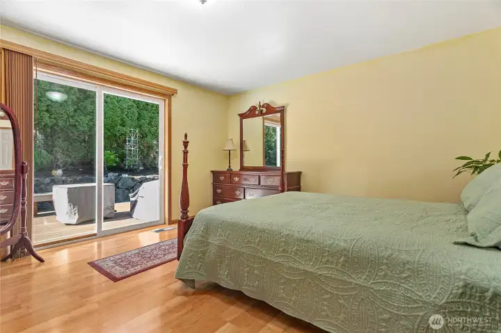 The primary suite features a sliding glass door providing seamless access to the rear deck, enhancing the property's indoor-outdoor living appeal.