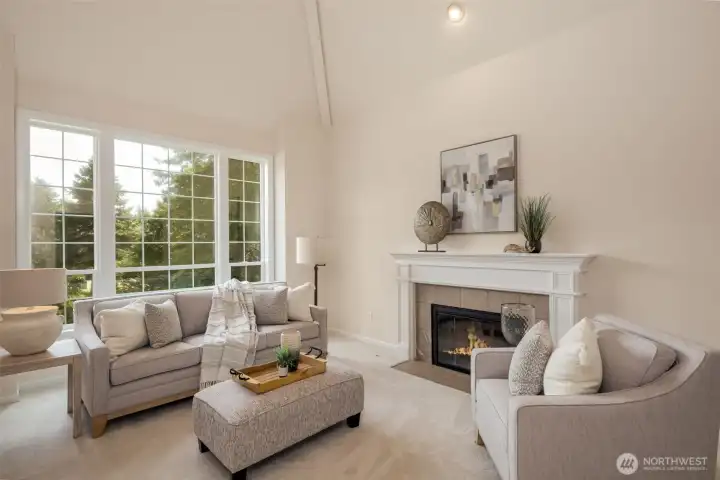 View of the living room featuring soaring ceilings and gas fireplace.