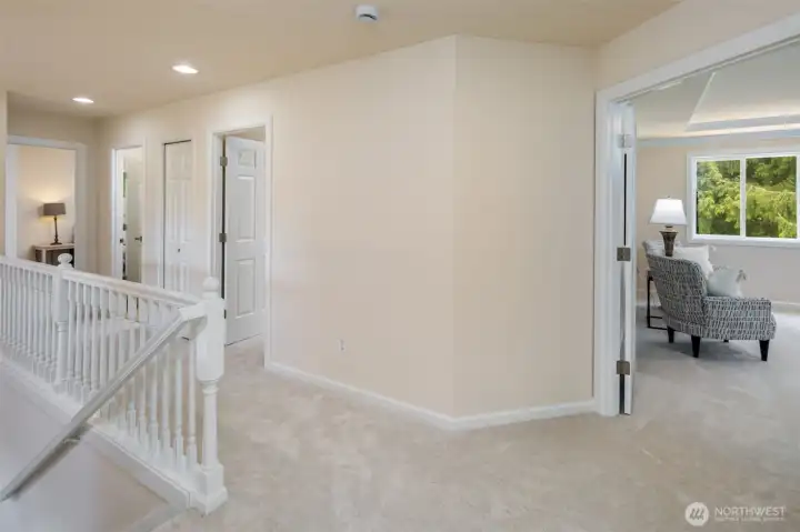 When you reach the top of the stairs, you'll find the double door entry primary bedroom.
