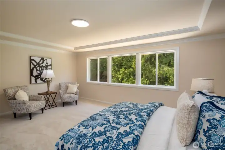 Primary bedroom with Walls of windows that overlook the backyard.