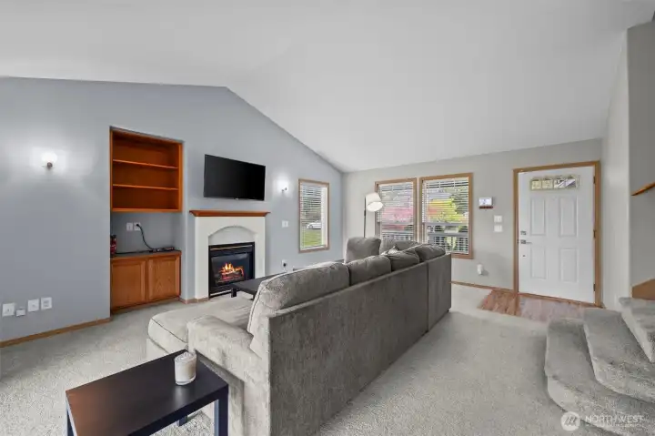 Vaulted ceilings and an open-concept living room featuring a gas fireplace.
