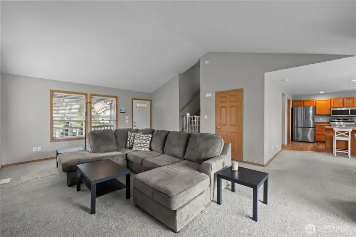 Vaulted ceilings and an open-concept living room featuring a gas fireplace.