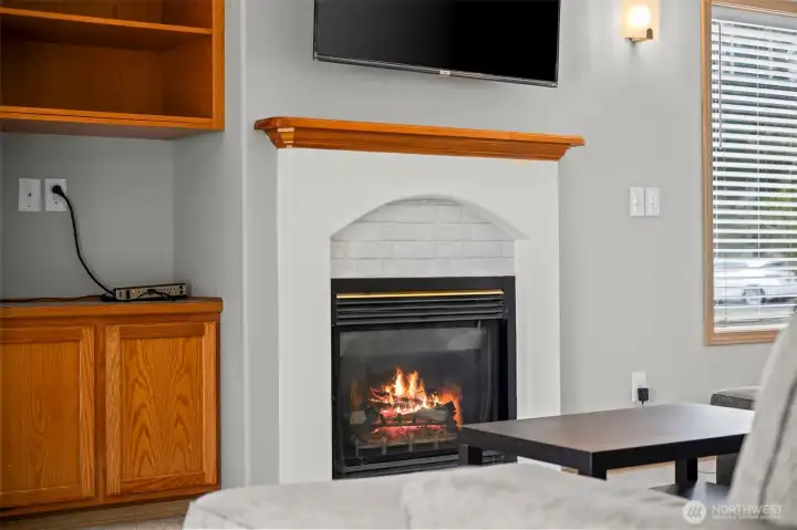 Vaulted ceilings and an open-concept living room featuring a gas fireplace.