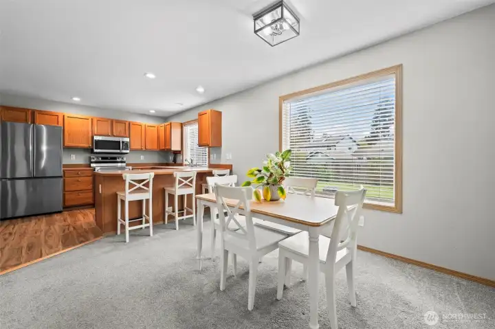 Dining room that flows seamlessly into the kitchen with stainless steel appliances.