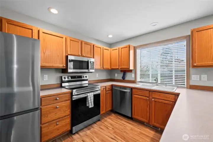 Dining room that flows seamlessly into the kitchen with stainless steel appliances.