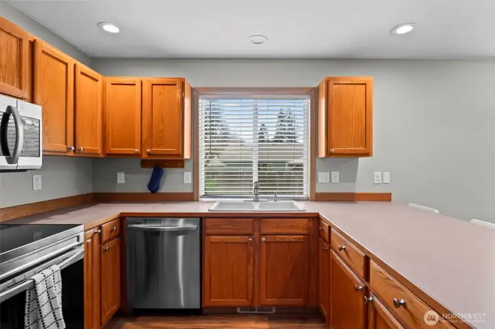Dining room that flows seamlessly into the kitchen with stainless steel appliances.