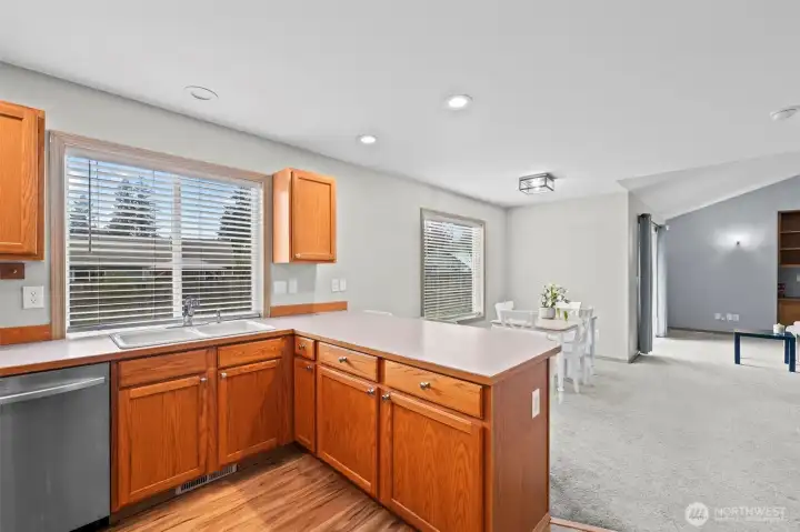 Dining room that flows seamlessly into the kitchen with stainless steel appliances.