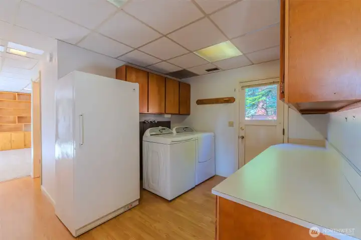 Laundry area with freezer that conveys with the home.
