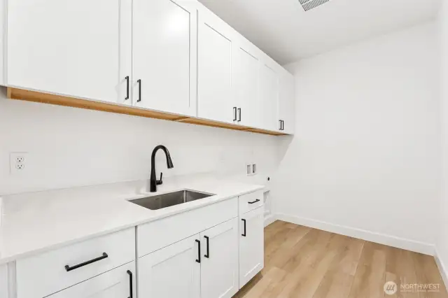 Laundry room with sink, cabinet and counterspace.
