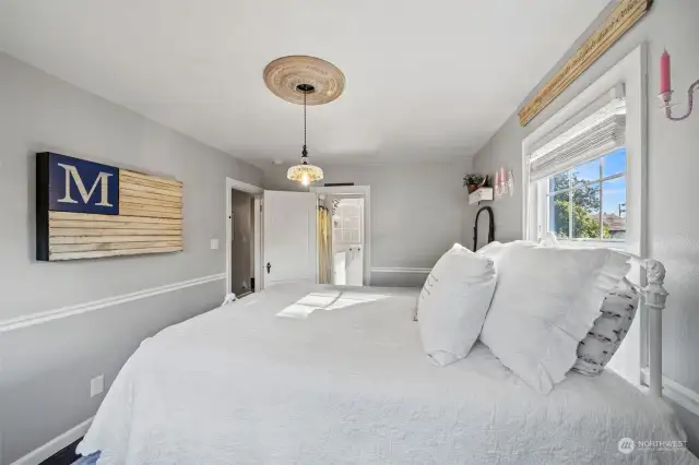 Primary bedroom located downstairs. Brightened with hanging chandelier.