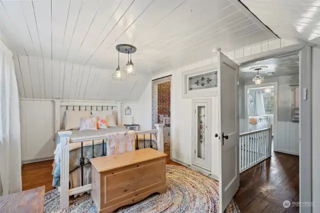 This bedroom holds  transom window art and a beautiful chandelier.