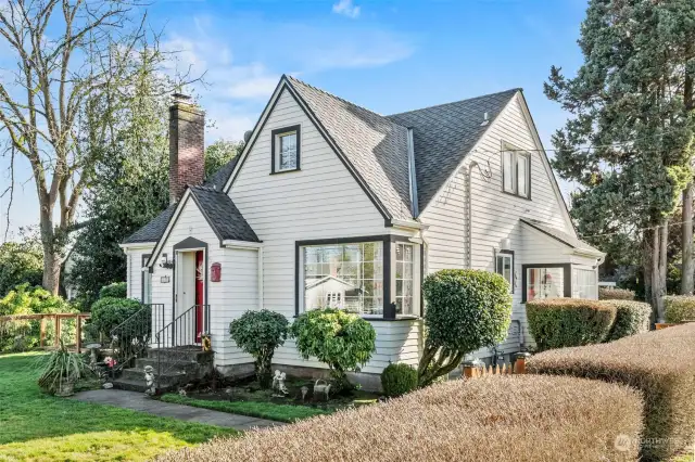 Sideways angle of home, showcasing side gate and complimenting hedges.