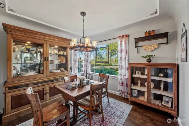 Dinning space along with a rustic chandiler to radiate the detailed trim and ceiling stencil.