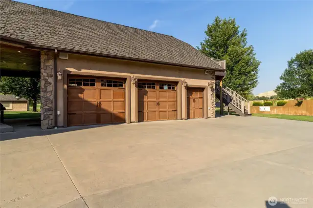 Three car garage and one golf cart garage with stair access to ADU