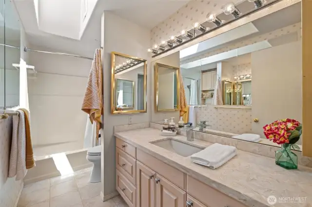 The full main-floor bath impresses with spacious design and a bright skylight.