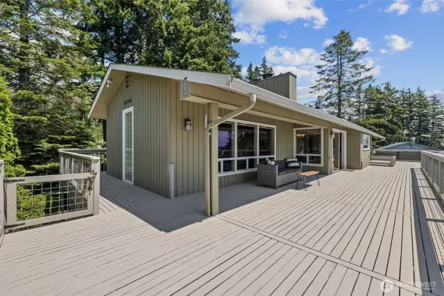 Massive wraparound deck with convenient stairs leading down to the patio and driveway.