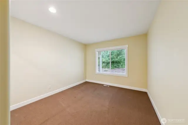 The second guest bedroom is generously sized and located toward the back of the home, offering peaceful views of the Forest Lands.