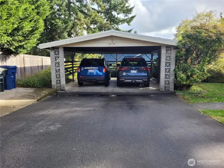 Carport with two full sized SUVs and room left over.