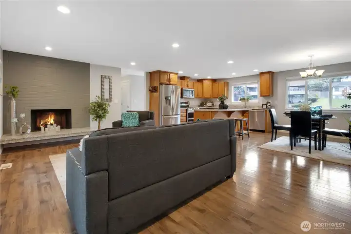 Upstairs Living Room featuring a wood fireplace and open concept dining and kitchen.