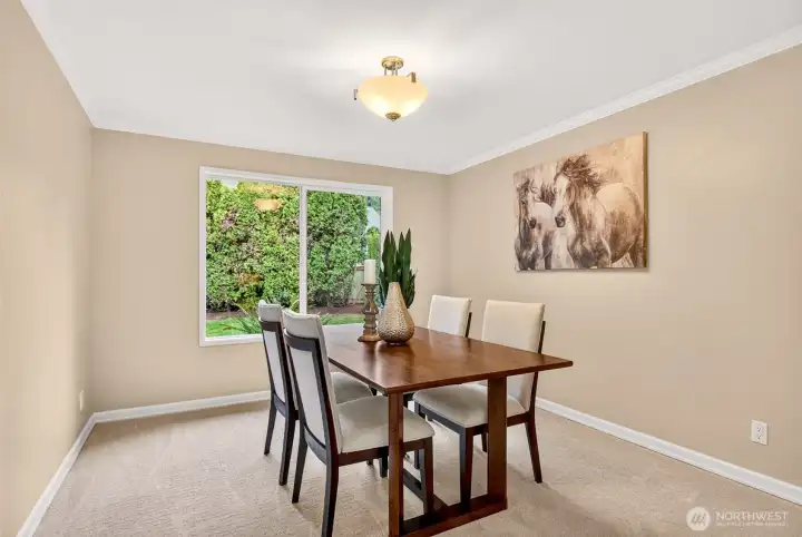 A dedicated dining room with a large window looks out to greenery for a private, calming backdrop. It is perfectly positioned for entertaining, while still feeling separate from the main living space.