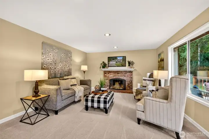 Comfortable main level living space anchored by a gas fireplace, plus large window overlooking the deck and backyard.