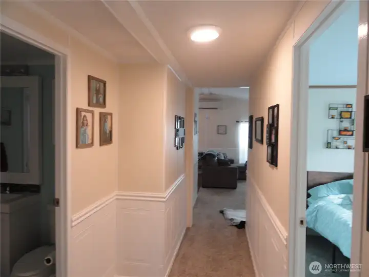 Hallway to living room, second bedroom on the right and bathroom on the left